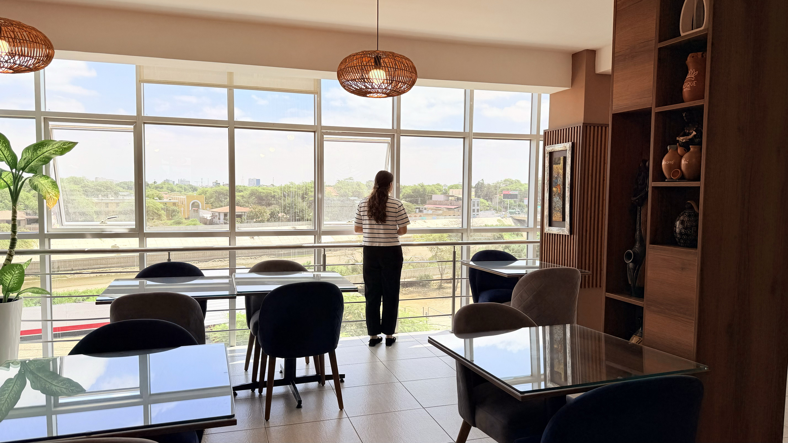 Cafetería del Cacique Hotel con ventanales y vista a la ciudad de Piura