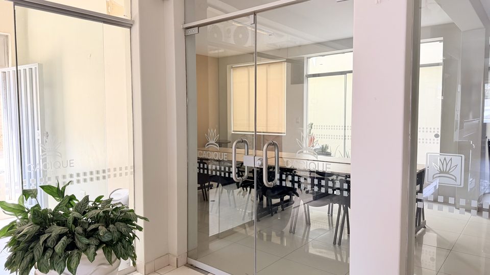 Puertas de vidrio del auditorio del Cacique Hotel, con el logotipo grabado