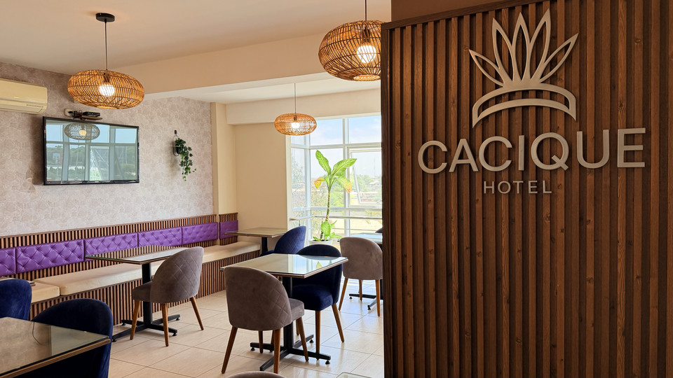 Comedor del restaurante junto al mural con el logotipo del Cacique Hotel