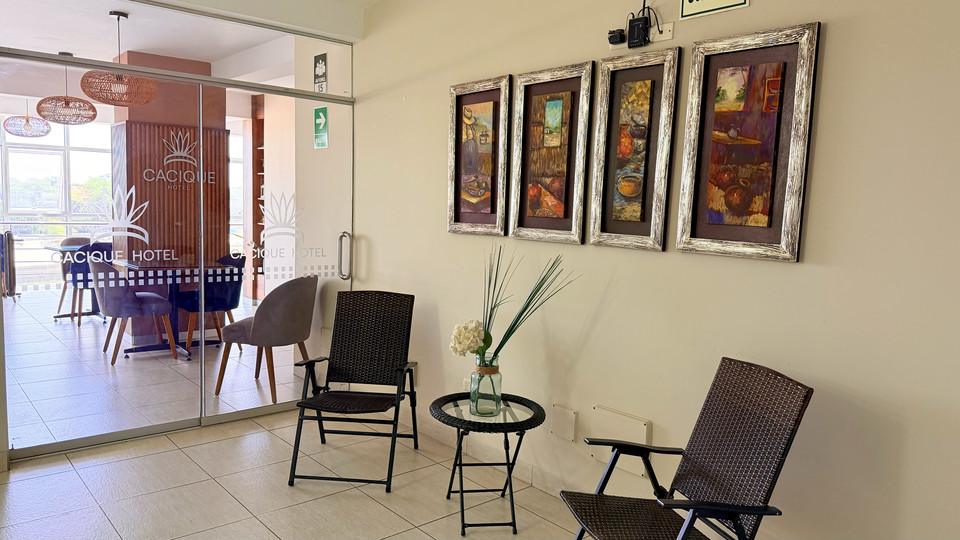 Terraza con mesas y sillas junto a la cafetería del Cacique Hotel