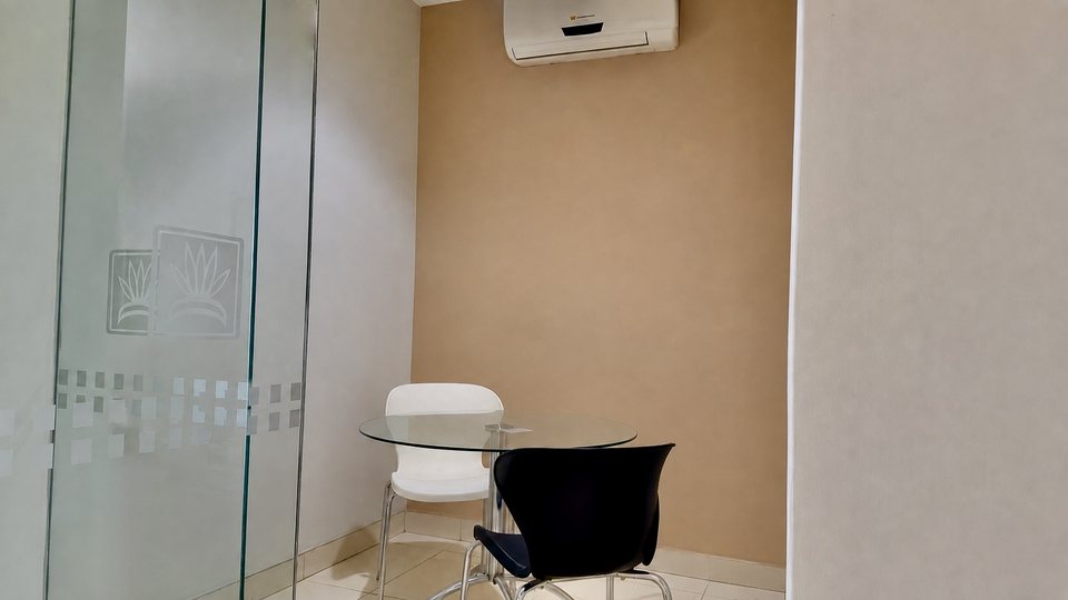 Sala de reuniones del Cacique Hotel, con mesa de vidrio y cerramiento vidriado